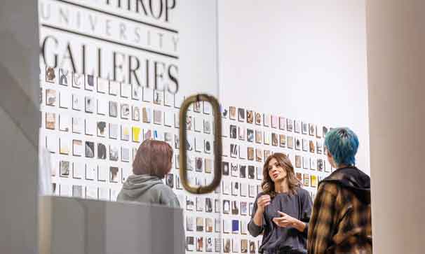students talking on campus in a gallery